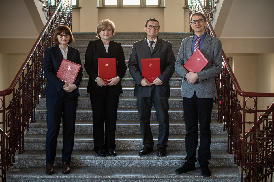 Four representatives of the partner institutions on the steps with the signed documents
